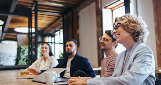 Conference meeting in an office, happy business team sits together in a boardroom