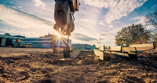 Bagger auf Baustelle bei Sonnenaufgang